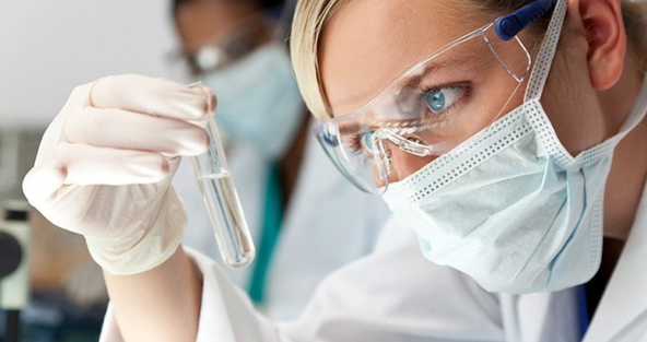 Blonde Frau mit Maske und Reagenzglas in der Hand 