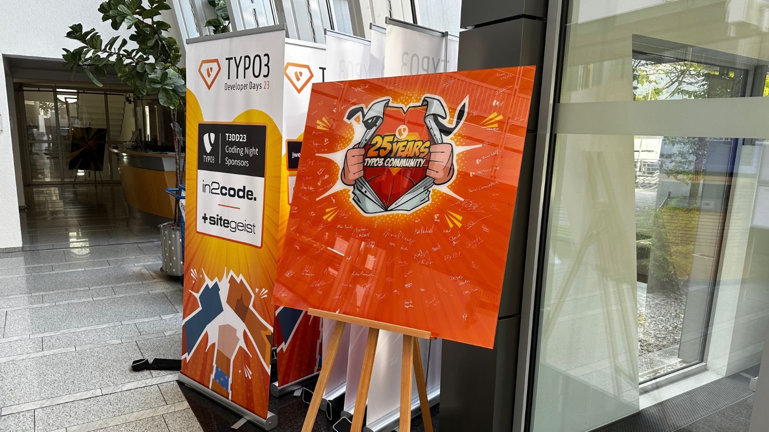 Eingang zu den TYPO3 Developer Days 2023 mit den dazugehörigen Plakaten im Superman-Motiven